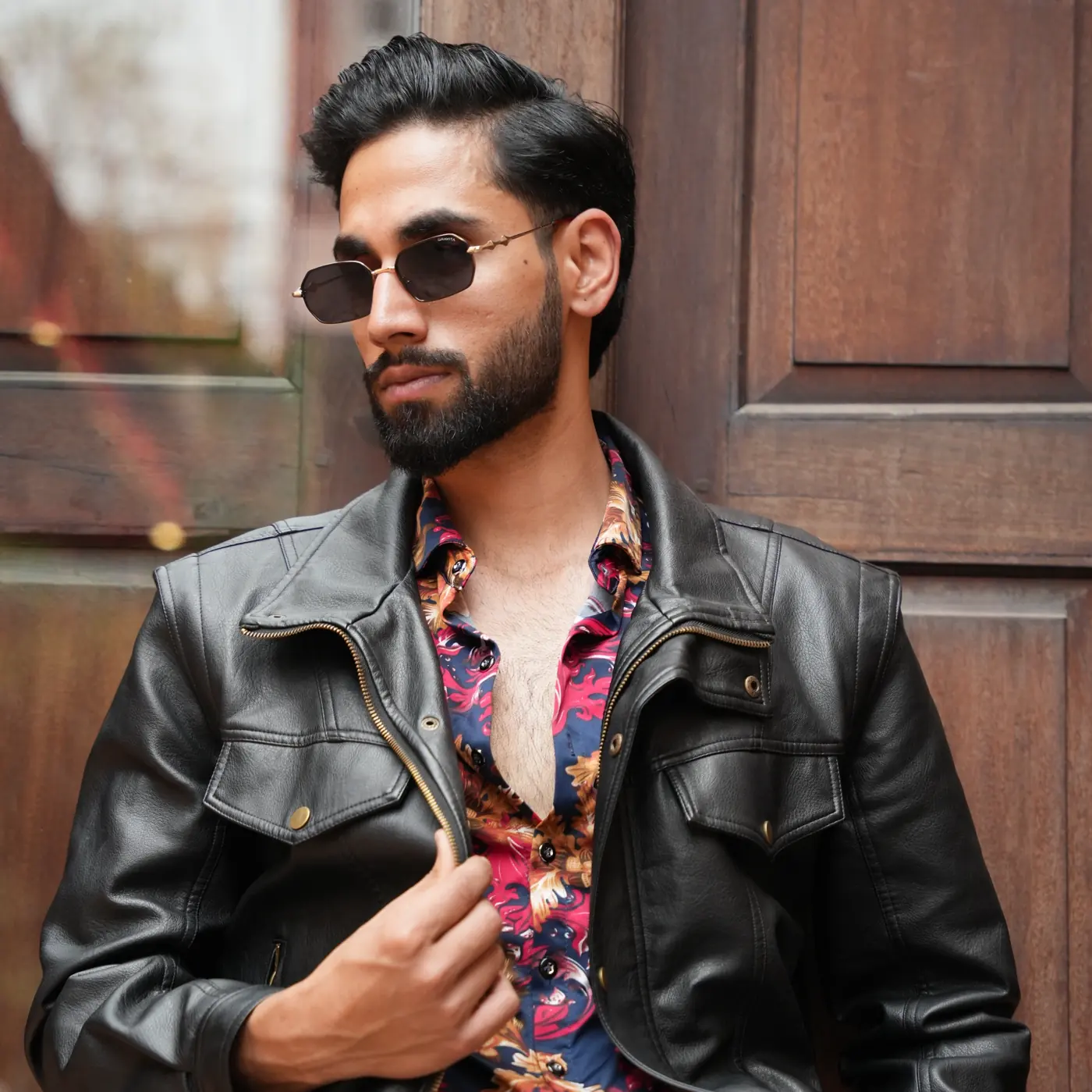 Man in a black leather jacket wearing Gravita sunglasses