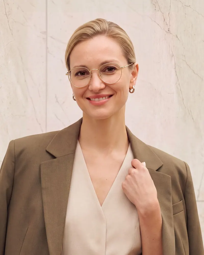 Woman wearing eyeglasses in a beige blazer